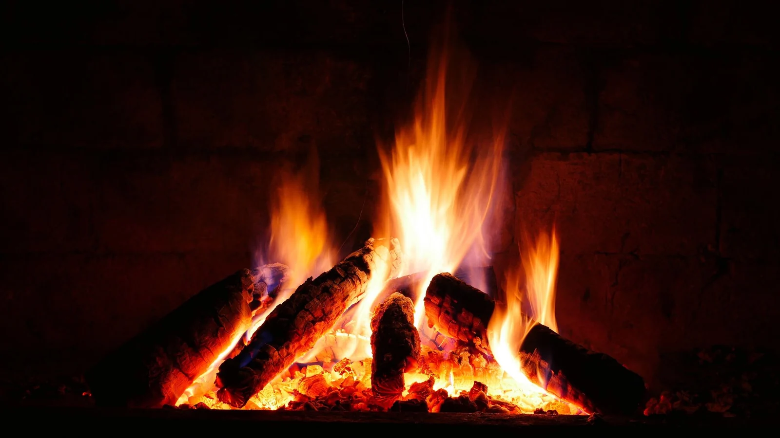 Glowing logs and flames in a brick firebox